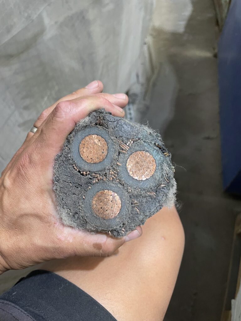 A close up shot of a large, stripped cable with copper inside